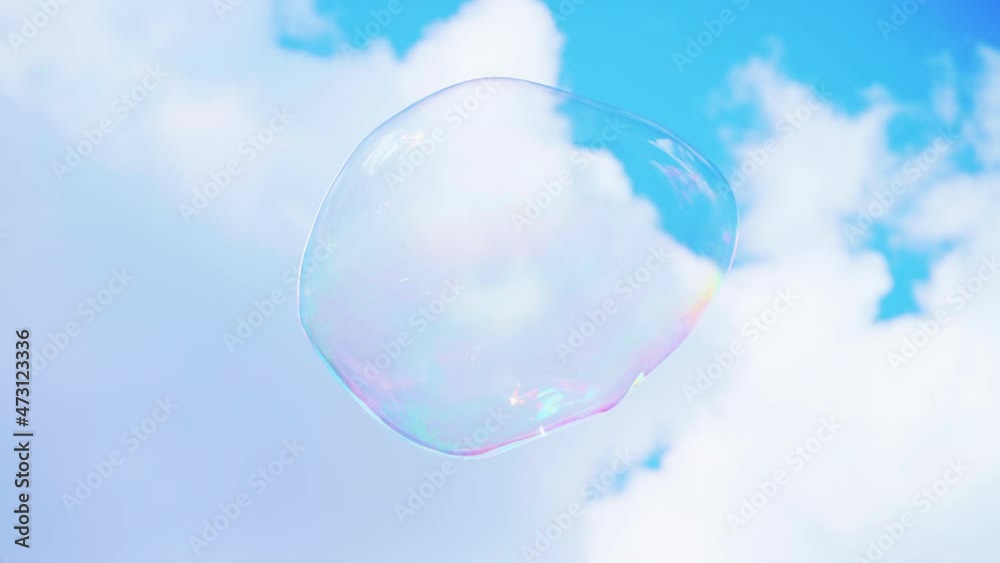 Big multicolored soap bubble on a background of blue sky and white clouds. rainbow colors on flying soap bubbles. holiday for happy children. magic, dreams.