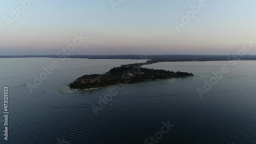 High altitude aerial view Sirmio Sirmione is a promontory at southern end of Lake Garda projecting 3.3 kilometers (2.1 mi) into water located in the province of Brescia in Lombardy northern Italy 4k photo