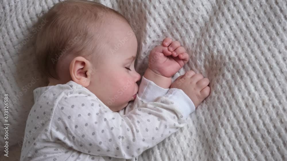Peaceful adorable baby sleeping on his bed in a room at home. Sleeping newborn baby concept. 6 month-old baby girl sleeps at home. A serene dream. Peaceful adorable baby sleeping on his bed in a room at home. Sleeping newborn baby concept. 6 month-old baby girl sleeps at home. A serene dream.