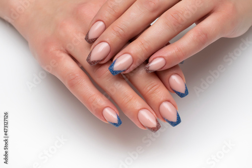 French beige, blue reflective manicure on long nails. Ballero nail shape. Close-up on a white background.