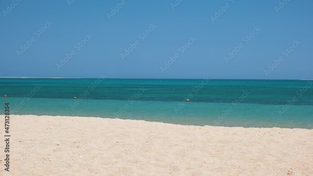 Seascape with surface of blue sea water with small ripple waves crashing on yellow sandy beach. Travel and vacations concept Seascape with surface of blue sea water with small ripple waves crashing on yellow sandy beach. Travel and vacations concept