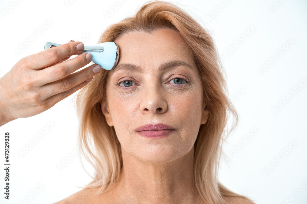 Retirement woman receiving a non-surgical rejuvenation procedure Retirement woman receiving a non-surgical rejuvenation procedure