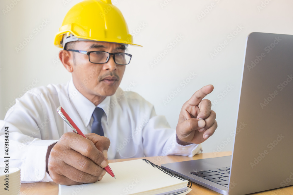 engineer writing note paper and point on laptop in workspace engineer writing note paper and point on laptop in workspace