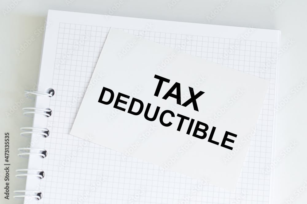 White card on the notebook on the table with text Tax Deductible