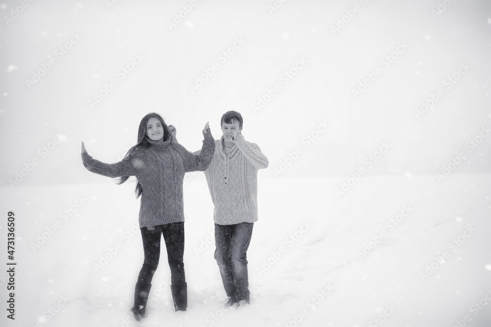 A loving couple on a winter walk. Man and woman on a date in the park in winter. Friends in a winter park A loving couple on a winter walk. Man and woman on a date in the park in winter. Friends in a winter park