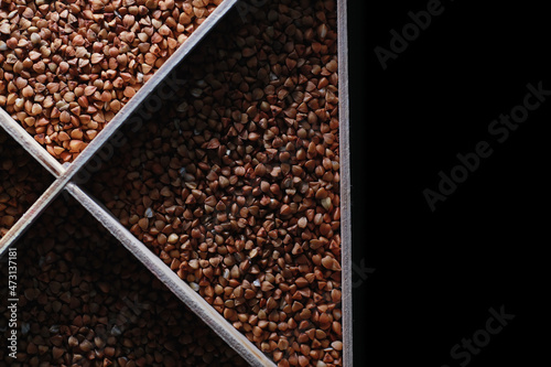 A set of grain cereals. Rice, buckwheat and millet groats in a wooden tray. A grocery set of cereals. Import of grain.