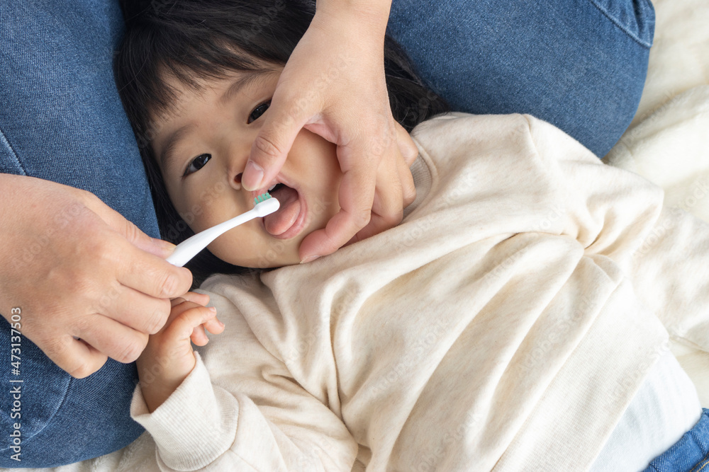 母親に歯を磨いてもらっている赤ちゃん(1歳4か月、女の子、日本人) 母親に歯を磨いてもらっている赤ちゃん(1歳4か月、女の子、日本人)