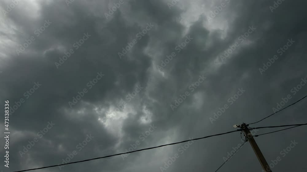 Stormy cyclone and rain clouds sweep over the electrical support and wires Stormy cyclone and rain clouds sweep over the electrical support and wires