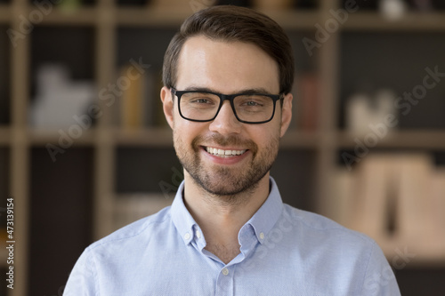 Happy handsome male business leader, businessman, professional in glasses looking at camera with toothy smile. Office employee, manager, small business owner head shot portrait