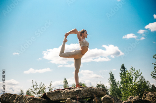 Young girl doing yoga outdoor. Young woman practicing yoga in bamboo house, nature on background.Female happiness.Caucasian woman practicing yoga on vacation on Bali island