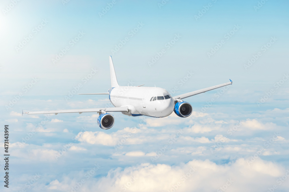 Airplane flying in blue sky above the clouds, travel by plane, international flight.
