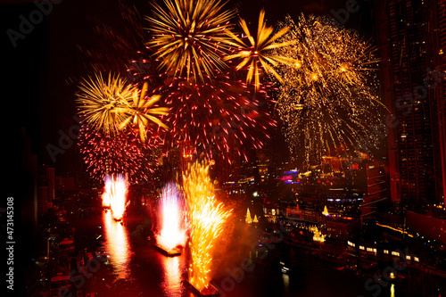 Fireworks lit up in the New Year's festival are scattered across the sky at midnight in a variety of colors in the middle of the Chao Phraya River, Thailand. #473145308