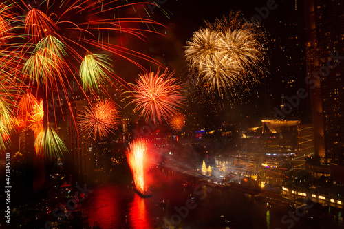 Fireworks lit up in the New Year's festival are scattered across the sky at midnight in a variety of colors in the middle of the Chao Phraya River, Thailand.