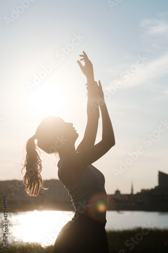 Silhouette of a dancing girl on the shore of Kaban Lake in Kazan at sunset