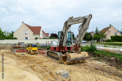 Pelle de chantier à chenilles avec compresseur rouleau compresseur sur un chantier de construction terrassement