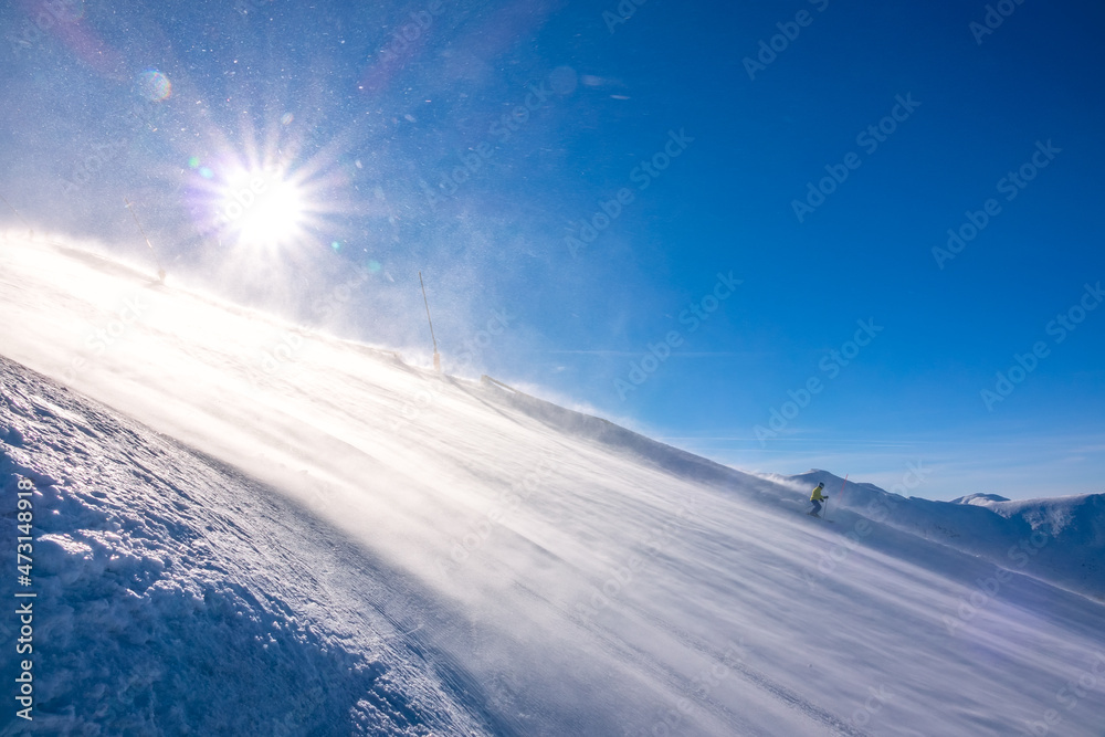 Lone Skier on a Sunny Slope and Blizzard Lone Skier on a Sunny Slope and Blizzard