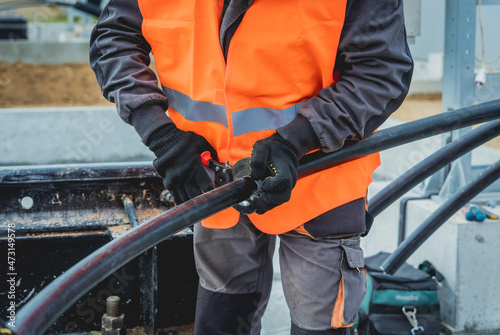 Two electrician builder workers installing high-voltage cable