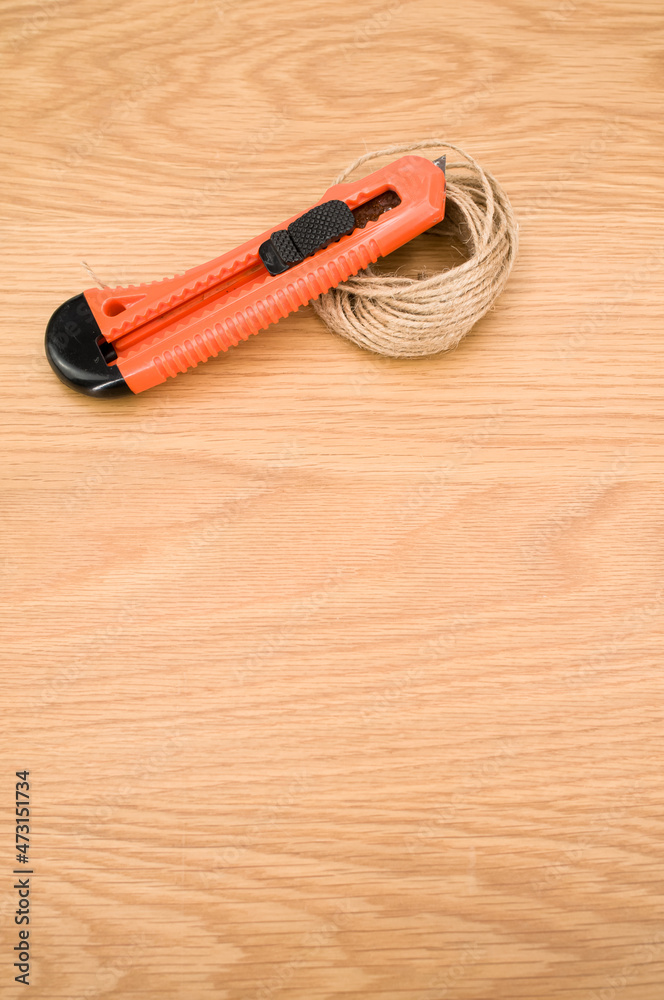 cutter and rough string on a wooden tabletop
