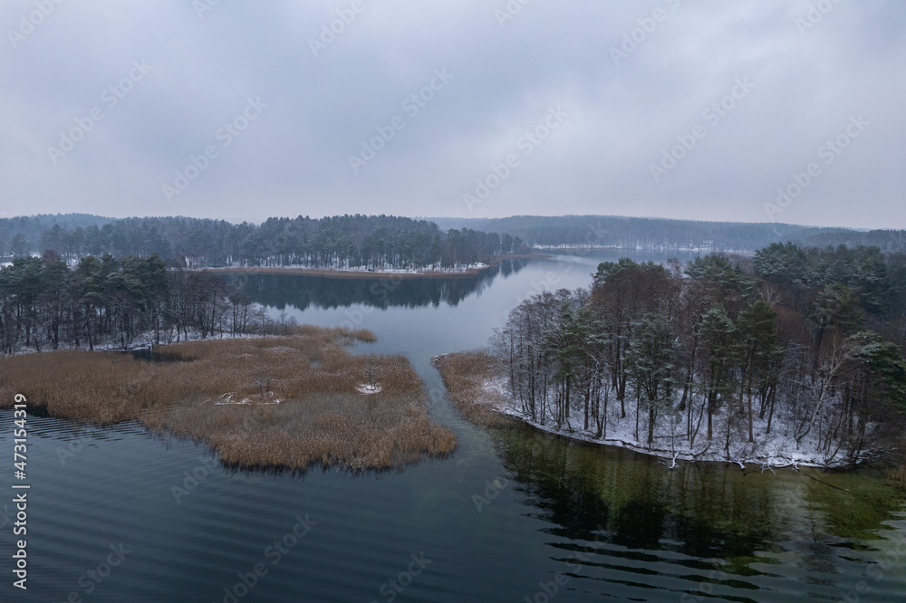 Fototapeta premium Aerial winter snowy view of lake in Trakai, Lithuania