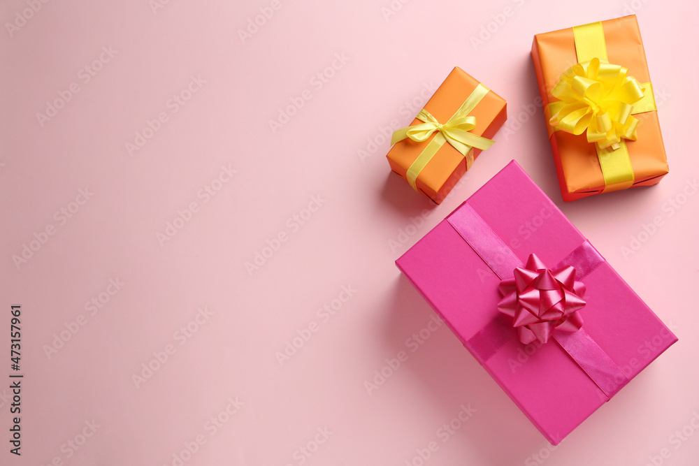 Bright gift boxes on pink background, flat lay. Space for text