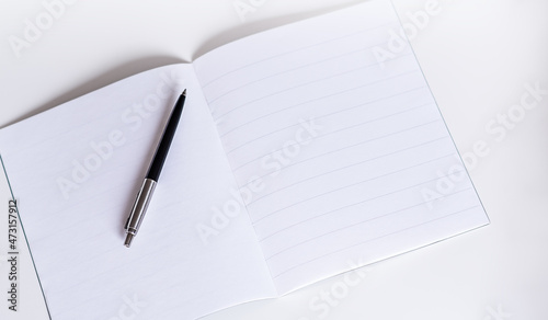 blank white booklet with pen on white background. Copy space.