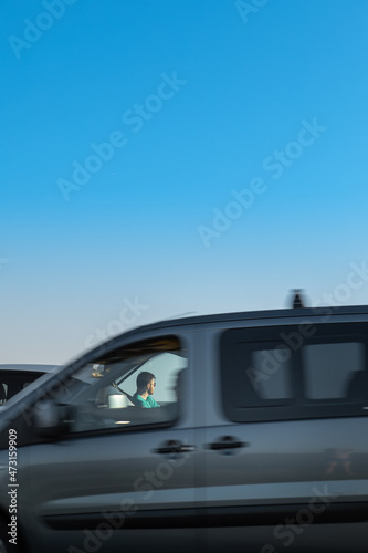 man traveler sitting near car at roadside of speedway at sunset