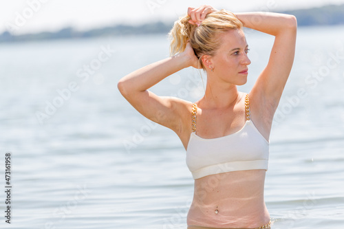 Young attractive blonde girl with perfect sport body in bikini on a beach in the summer © Collins Photography