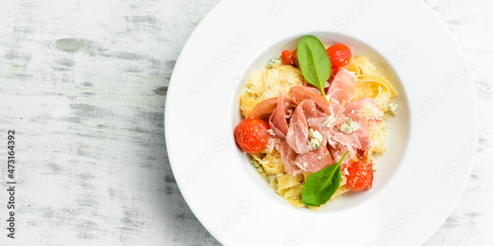 Pasta with prosciutto, blue cheese and tomatoes. Italian cuisine. Menu. Top view. Pasta with prosciutto, blue cheese and tomatoes. Italian cuisine. Menu. Top view.