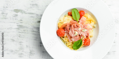 Pasta with prosciutto, blue cheese and tomatoes. Italian cuisine. Menu. Top view.