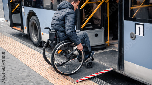 Person with a physical disability enters public transport with an accessible ramp. photo