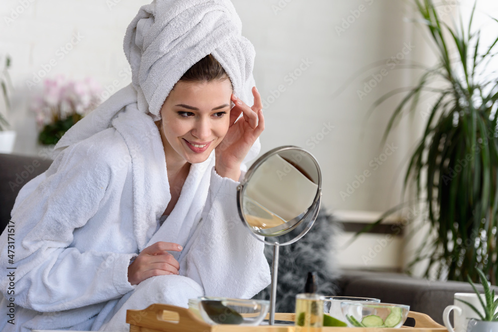 Portrait of a young beautiful woman wearing a bathrobe at home. doing her daily skincare routine with natural cosmetics Portrait of a young beautiful woman wearing a bathrobe at home. doing her daily skincare routine with natural cosmetics
