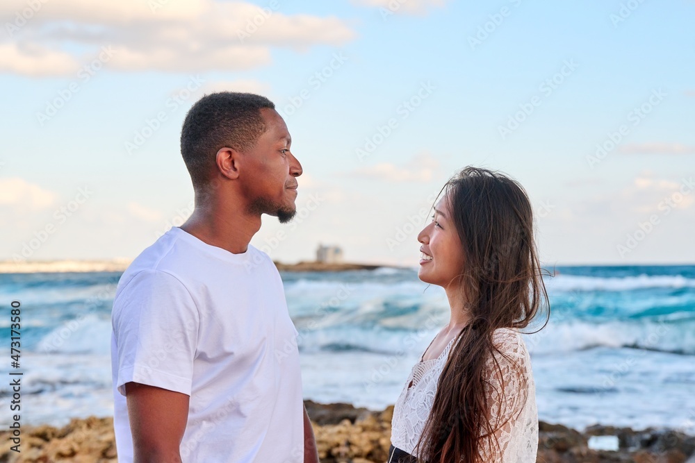 Young beautiful couple looking in the eyes in profile, on the seascape Young beautiful couple looking in the eyes in profile, on the seascape