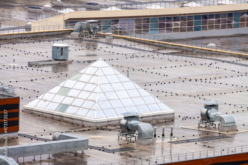 Bilde på lerret Aerial view pyramid-shaped skylight window flat roof with air conditioners top modern apartment building