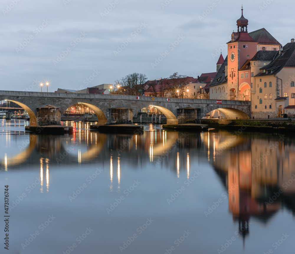 Ausschnitt der steinernen Brücke  in der Dämmerung beleuchtet mit Spiegelungen