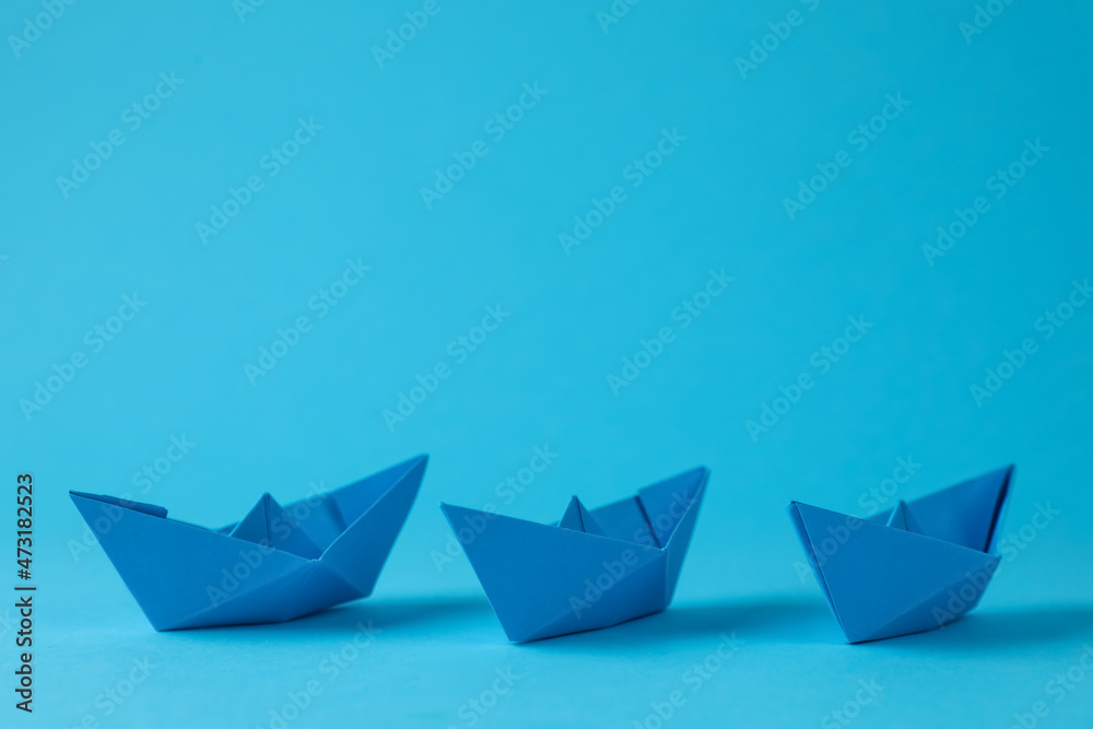 Handmade paper boats on light blue background. Origami art Handmade paper boats on light blue background. Origami art