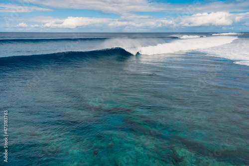 Blue waves in transparent ocean. Aerial view of surfing wave