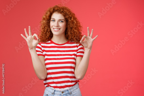 Fine relax everything perfect. Satisfied good-looking redhead cheerful sassy girlfriend curly haristyle show okay ok confirm gesture smiling approval agree good terms stand red background