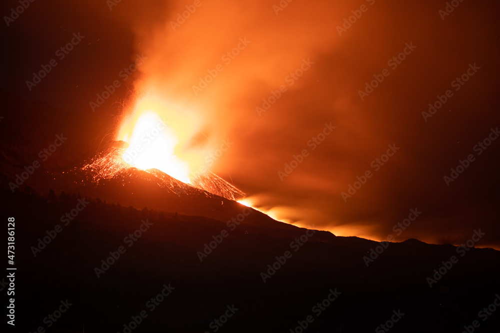 Cumbre Vieja / La Palma (Canary Islands) 2021/10/28. Long exposure nigh shot of the Cumbre Vieja volcano eruption. The main cone of the volcano, the two most active lava vents, and the main lava flow. Cumbre Vieja / La Palma (Canary Islands) 2021/10/28. Long exposure nigh shot of the Cumbre Vieja volcano eruption. The main cone of the volcano, the two most active lava vents, and the main lava flow.
