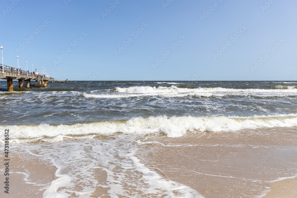 The waves in the seaside resort of Zinnowitz on the island of Usedom surround the great pier - obrazy, fototapety, plakaty 