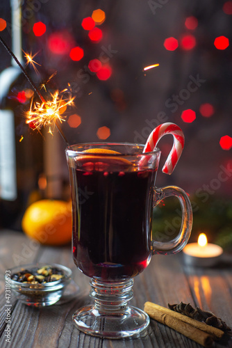 Mulled wine in a glass with sparklers and spices on a bokeh background