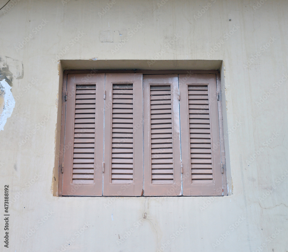 Window closed shutters on the wall of a house