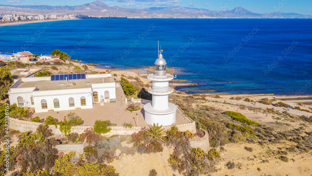 Faro del Cabo de las Huertas en Alicante , vista aérea en un día luminoso y con el mar peinado por el fuerte viento de poniente y con un fuerte color azul del mar.