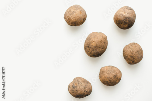 Potatoes on a white background. Dirty potatoes. 