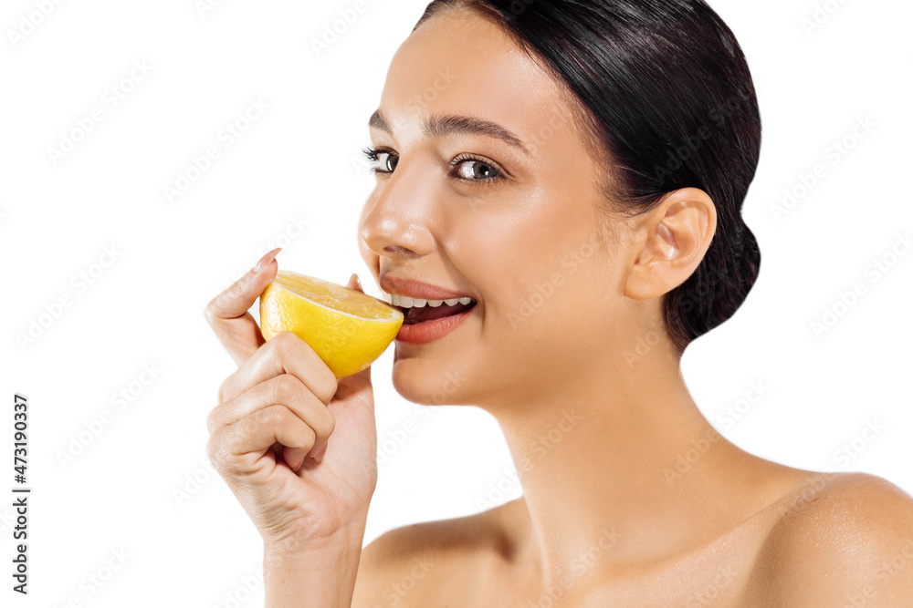 Woman and fruit portrait. model holds a juicy orange near her face and looks at the camera on a white background Woman and fruit portrait. model holds a juicy orange near her face and looks at the camera on a white background