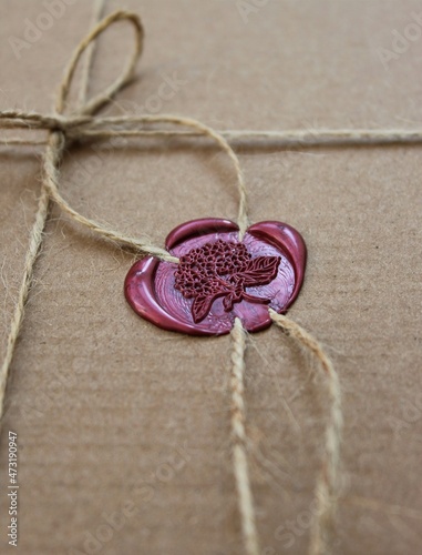 Burgundy wax seal with the imprint of hydrangea on the gift box