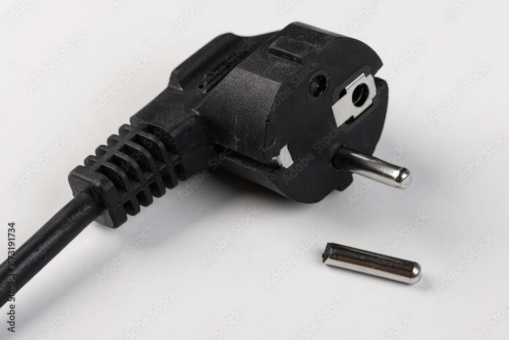 a broken plug of an electric cable on a white background, one pin is broken off a broken plug of an electric cable on a white background, one pin is broken off