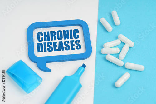 On the white and blue surface are a marker, tablets and a plate inside which the inscription - CHRONIC DISEASES