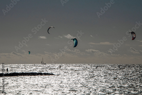 Kitesurfer in the sea and sailing boat