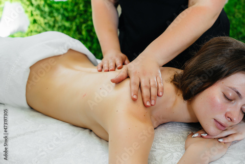 A young pretty girl is enjoying a professional cosmetological massage at the Spa. Body care. Beauty salon