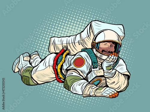 The joyful astronaut is lying down. Relaxed funny pose. Peace and relaxation